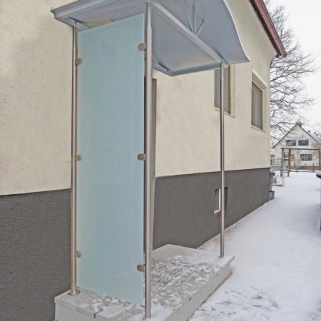 Geschwungenes Vordach aus Aluminium mit Seitenverglasung